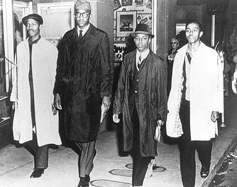 Ezell Blair (sağdan ikinci, kısa boylu ve şapkalı) diğer arkadaşlarıyla oturma eylemini başlattığı gün Greensboro restoranından çıkarken (1 Şubat 1960)